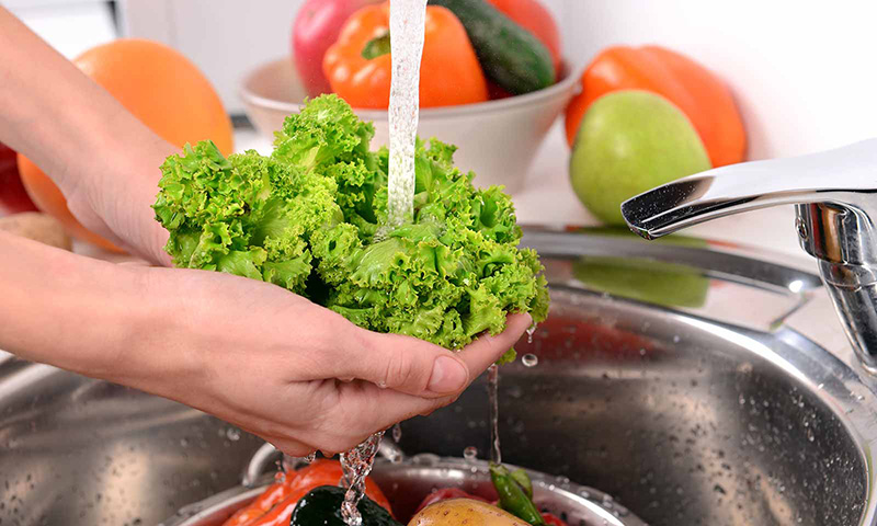 Rửa rau dưới vòi nước chảy